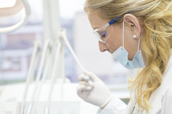 Medical scientist in a lab wearing a mask over her mouth, but not over her nose.