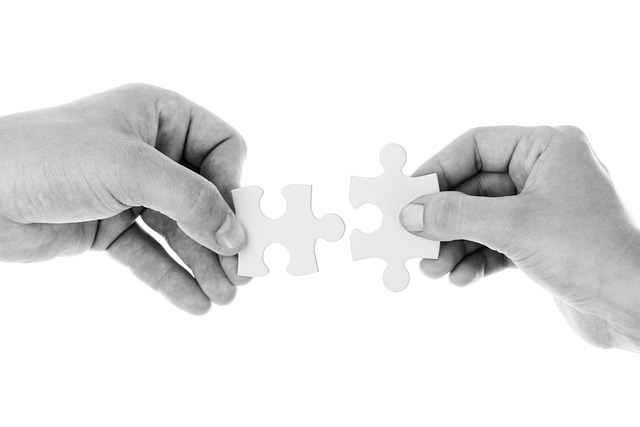 Hands putting two jigsaw pieces together